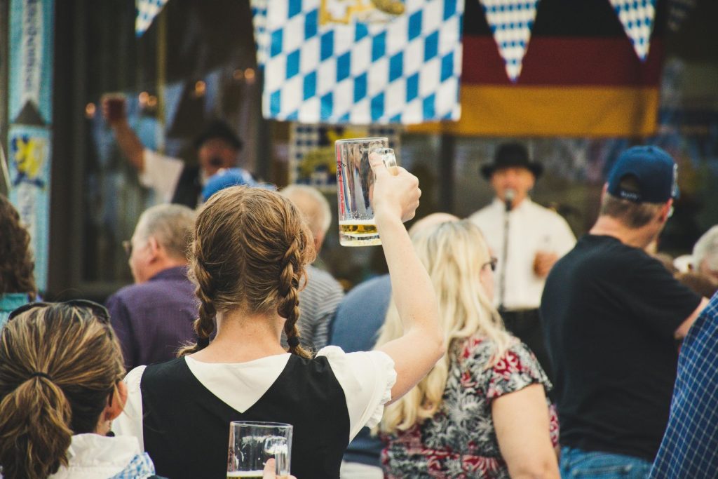 Girl in a crowd holding up an empty beer stein