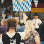 woman holding up empty beer stein in a crowd
